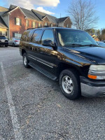 2001 Chevrolet Suburban in black, parked with clean exterior and new tires, offering reliable performance and spacious interior.