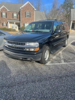 2001 Chevrolet Suburban LT with 89,000 miles, black exterior, parked in a residential area.