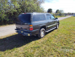2006 GMC Yukon XL K1500 in gray parked on grass, showcasing its rugged design and 4x4 capabilities.