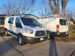 Two 2017 Ford Transit 250 cargo vans parked side by side in good condition, featuring roof racks.