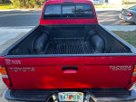 2003 Toyota Tacoma Pre-Runner in red, showing truck bed and tailgate, in good overall condition.