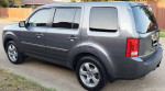 2012 Honda Pilot EX FWD parked on the street, showcasing its modern design and alloy wheels.