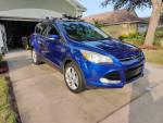 2013 blue Ford Escape SEL parked in driveway, featuring leather interior and roof racks.