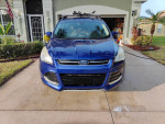 Front view of a blue 2013 Ford Escape S FWD parked in a driveway, showcasing its sleek design and well-maintained condition.