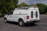 2008 Ford F150 commercial truck with cap, ideal for contractors or travelers, parked outdoors.