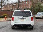 Rear view of a 2014 Honda Pilot EX-L with alloy wheels parked on a residential street.