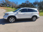 2011 Honda CR-V EX-L in white with leather interior parked on a driveway surrounded by trees