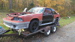 Red 1987 Ford Mustang GT roller on a trailer, minimal rust, no engine, great for parts or drag car.