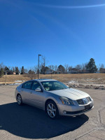 2005 Nissan Maxima in silver parked in a clear, sunny environment with new tires and clean features.