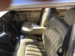 Interior of a 1973 Rolls-Royce Silver Shadow with beige leather seats and classic dashboard features.