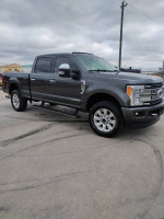 2017 Ford F250 Platinum truck with 98k miles, gray exterior, and alloy wheels parked on a concrete surface.