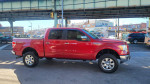 2011 Ford F-150 Lariat 4WD in red parked on the street with a clean exterior and chrome wheels.