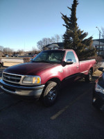 Red Ford F250 truck with a clean body, showing signs of engine issues and water in oil.