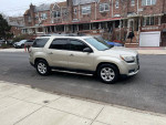 2013 GMC Acadia SLE in a snowy street, featuring third row seats and a backup camera.