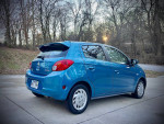 2015 Mitsubishi Mirage in blue parked outdoors, showing its compact design and low mileage.