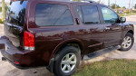 2015 Nissan Armada in maroon color, featuring third-row seating and a clean exterior, perfect for families.