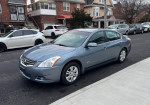 2010 Nissan Altima Hybrid sedan parked on the street, well-maintained with 122K miles, clean exterior and interior.