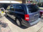 2009 Chrysler Town & Country minivan parked in driveway, showcasing stow and go seating feature.