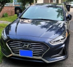 Front view of a 2018 Hyundai Sonata SE FWD sedan in black, showcasing sleek design and hybrid features.