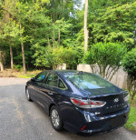 2018 Hyundai Sonata SE FWD parked in a green area, showcasing its black exterior and sleek sedan design.