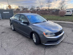 2015 Volkswagen Jetta SE in gray, showcasing alloy wheels and clean body, parked outdoors