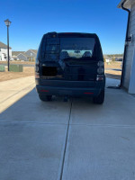 Rear view of a 2006 Land Rover LR3 in black with beige interior parked on a driveway.