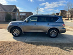 2019 Nissan Armada SL RWD in silver, showcasing features like leather seats and a sunroof, parked in a driveway.