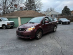 2008 Suzuki SX4 sedan parked, showcasing its maroon color and reliable features for city driving.