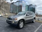 2006 BMW X5 3.0i AWD gray SUV parked with modern buildings in the background