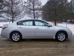 Side view of a 2012 Nissan Altima 2.5S with 116k miles, parked on a snowy road.
