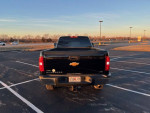Rear view of a 2012 Chevrolet Silverado 1500 LTZ 4WD parked in an empty lot at sunset.