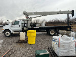 2013 Ford F-750 crane truck equipped with National Crane, flatbed, and low mileage, parked on gravel.