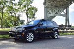 2013 BMW X5 xDrive35i SUV showcasing its sleek design and luxury features parked under a bridge in a scenic location.