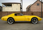 1974 Chevrolet Corvette in bright yellow, fully restored with performance upgrades, parked in a stylish setting.