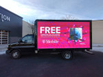 2018 Chevrolet Express cutaway truck with LED billboard displaying T-Mobile Samsung Galaxy S21 5G advertisement.