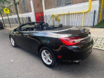 2016 Buick Cascada Premium convertible parked on a street, showcasing its sleek design and open roof.