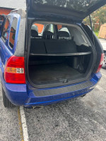 2006 Kia Sportage trunk with ample space, showcasing reliable daily driving condition and original faded paint.