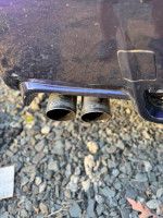 Close-up of COBB exhaust tips on a 2013 Subaru Impreza WRX showcasing aftermarket modifications.