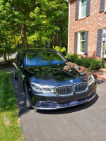 2017 BMW 7-Series 750i x L parked in front of a house, showcasing its sleek design and elegance.