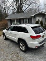 2015 Jeep Cherokee with 106,000 miles parked in front of a house, showcasing its excellent condition and features.