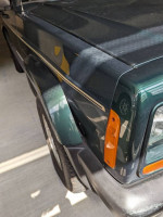 Close-up of a 2001 Jeep Cherokee Sport showing the front left fender and headlight.