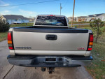 Rear view of a 2005 GMC Sierra 1500 truck showing the bed and tailgate in a residential area.