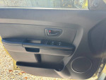 Interior view of 2013 Kia Soul door panel showcasing controls and speaker