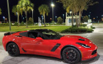 2015 Chevrolet Corvette Z06 in red, showcasing sporty design and performance at night.