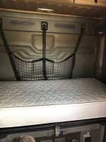 Interior view of a 2013 Freightliner Cascadia sleeper cabin with a comfortable mattress and storage net