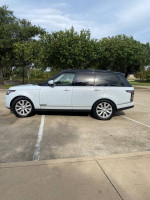 2016 Land Rover Range Rover HSE 4WD, white SUV parked with trees in background, showing sleek design and new tires.