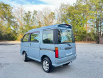 Blue Daihatsu MicroVan with automatic transmission parked in a lush environment, ideal for family adventures.