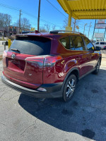 2018 Toyota RAV4 LE in red, parked with visible exterior details and surroundings.