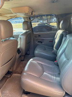Interior view of a 2005 Chevrolet Suburban with well-maintained leather seats and spacious back seating area.