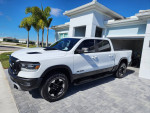 2022 Ram Rebel extended cab truck with low mileage parked in front of a modern house